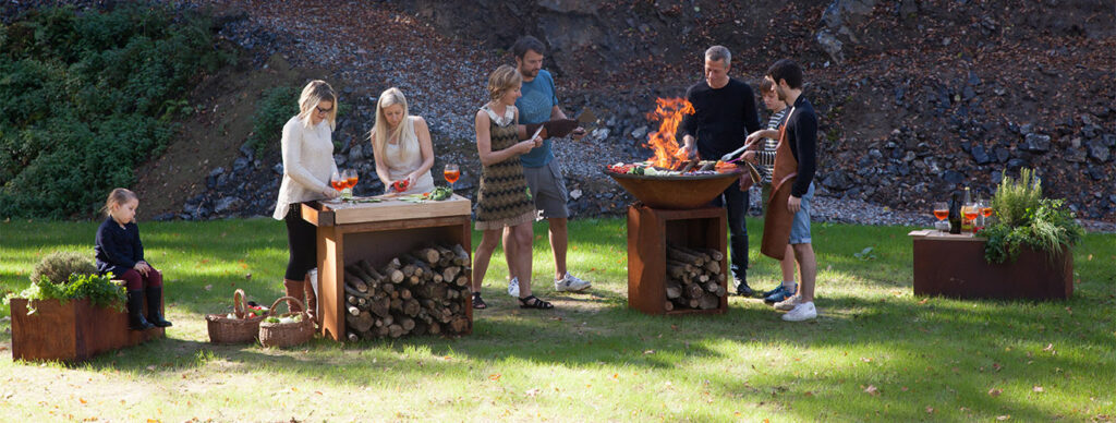 Designerskie palenisko ogrodowe OFYR Classic ze stali Corten z charakterystyczną brązową patynąna tarasie przy altanie